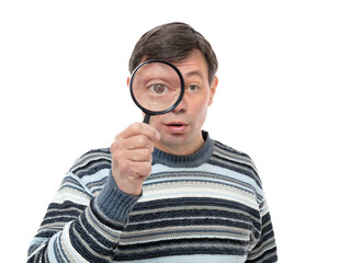 Portrait of anxious fifty year old guy looking through a magnifying glass, isolated on white background. Brunette man in striped sweater posing in studio.