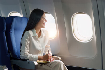 Beautiful Asian businesswoman working with laptop in aeroplane. working, travel, business concept