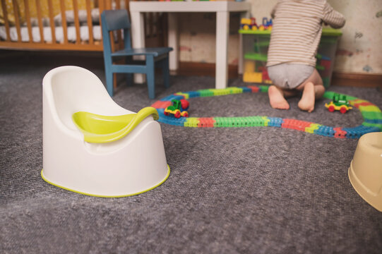 The pot stands in the children's room against the background of a playing child and toys