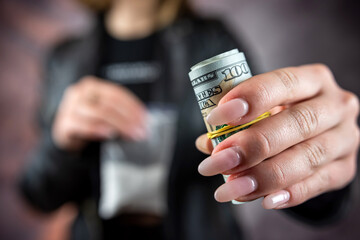 woman wear black cloth hold dollar and dose of cocaine or heroine
