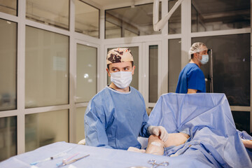 doctor and an assistant in the operating room for surgical venous vascular surgery clinic
