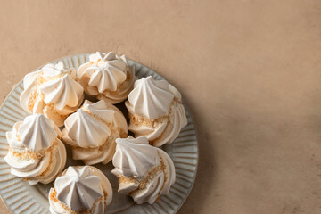 Sweet Meringue on the plate on beige background.