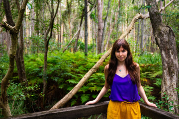 Beautiful girl in colorful clothes andmires and walks in Brisbane Koala Bushlands Park, Queensland, Australia