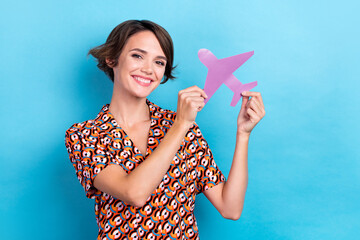 Photo of funky sweet woman wear print blouse smiling rising paper plane isolated blue color background