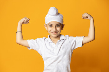 indian sikh kid showing biceps in front of camera .