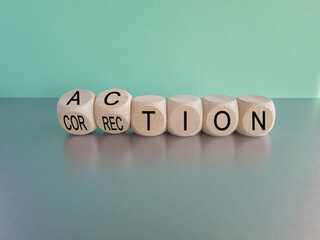 Action or correction symbol. Turned wooden cubes and changes the word correction to action. Beautiful blue background, copy space. Business and action or correction concept.