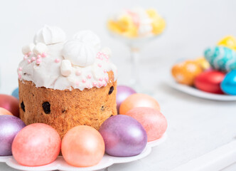 Painted Easter eggs with decorated Easter cake on white background close up with selective focus. Happy Easter concept