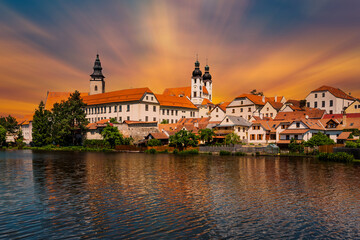 Fototapeta premium View of Telc across pond with reflections, South Moravia, Czech Republic.