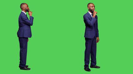 African american worker doing hush silence gesture, keeping secret and being confidential. Private entrepreneur showing secrecy and silent sign in studio, confident businessman.