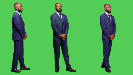 Young office worker with formal suit smiling on camera, posing with confidence over full body greenscreen. Male entrepreneur and businessman feeling sylish and modern, professional person.