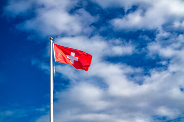 Swiss flag on flagpole. waving in the wind