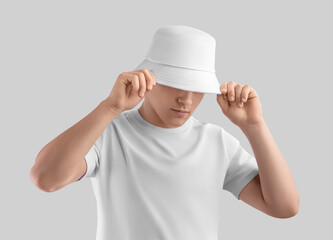 Mockup of white panama on posing guy in t-shirt, sun hat, blank accessory for design, print, brand, advertising.