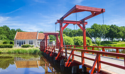 Fototapeta na wymiar Red wooden bridge in historic village Bourtange, Netherlands