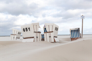 Germany, Schleswig-Holstein, St. Peter-Ording, Hooded beach chairs on sandy beach