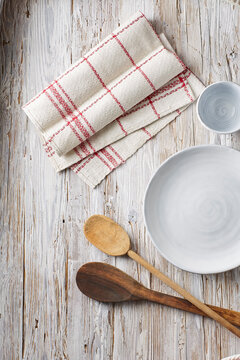 Empty bowl, cup, dish towel and wooden spoons