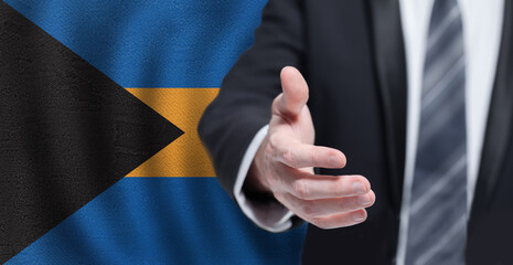 Business hand on Bahamian flag background. Welcome to the Bahamas