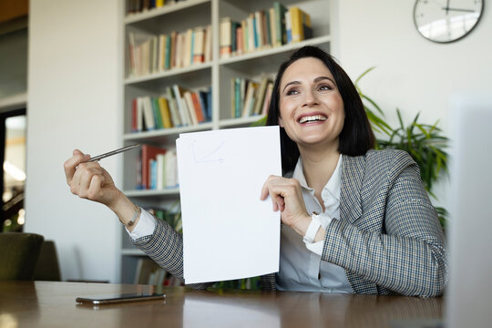 Happy businesswoman pointing at blank document in office