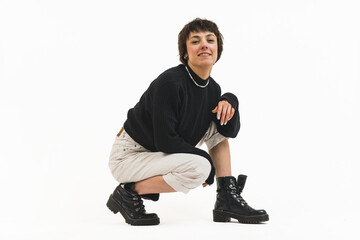 Woman crouching and bending on her knee for a model photoshoot smiling looking into camera 