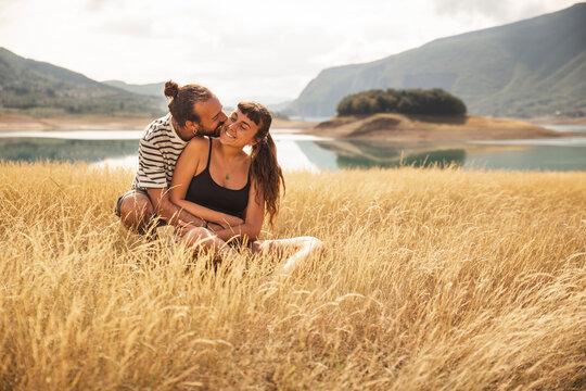 Happy man embracing woman in front of Rama Lake