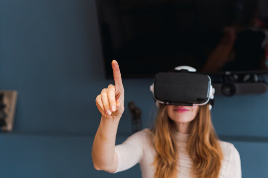 Woman wearing virtual reality headset gesturing at home