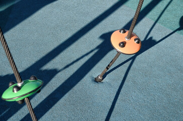 Climbing ropes at kids playground, climbing net, ropes in the playground, jungle gym for climbing kids. Modern playground with colorful rubber flooring for Children.