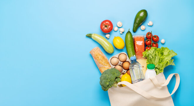 Shopping bag full of healthy food on blue