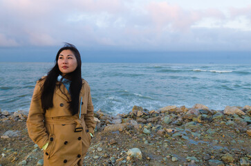 Dramatic portrait of a girl by the sea in winter