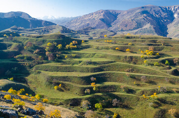 Mountain landscape with green agricultural terraces on the slopes in the Caucasus mountains.