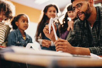 Diverse young students learn about wind power during a science lesson in elementary school