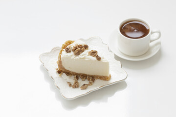 cup of coffee and cheesecake  on white table