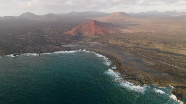 Acantilados de los Hervideros y monta&ntilde;a roja, en Lanzarote desde punto de vista a&eacute;reo en 4k60

