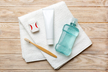 Obraz na płótnie Canvas Mouthwash and other oral hygiene products on colored table top view with copy space. Flat lay. Dental hygiene. Oral care products and space for text on light background. concept