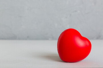 gift box with red bow and red heart on colored background. Perspective view. Flat lay