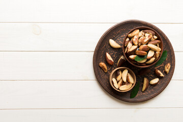 Fresh healthy Brazil nuts in bowl on colored table background. Top view Healthy eating bertholletia concept. Super foods