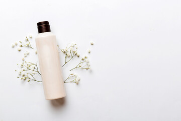 Fancy healthcare bottles for cream with gypsophila branch. Natural oranic spa cosmetics concept. Mockup, template, Top view