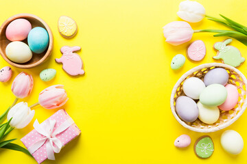 Easter frame with eggs, gift box and tulip on a colored background. The minimal concept. Top view Happy Easter composition. Card with a copy space of the place for the text