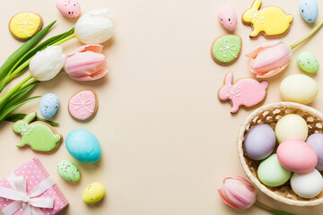 Easter frame with eggs, gift box and tulip on a colored background. The minimal concept. Top view Happy Easter composition. Card with a copy space of the place for the text