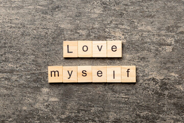 Love myself word written on wood block. Love myself text on cement table for your desing, Top view concept