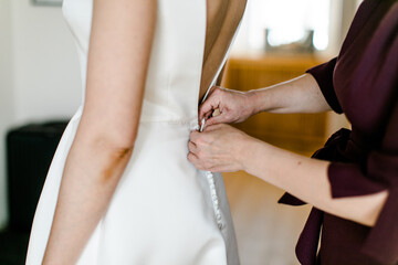 Fototapeta na wymiar Braut beim Anziehen des Brautkleids