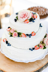 weiße Hochzeitstorte mit Rose und Beerendeko