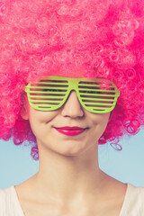 Portrait of beautiful woman in pink wig and green glasses