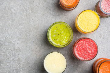 Obraz na płótnie Canvas Glasses of fresh juice on gray stone table. Food background