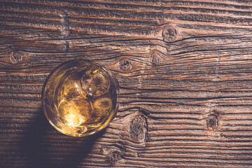 Glass of whiskey on an old wooden table