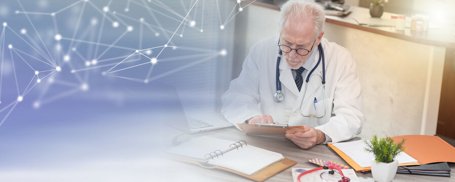 Senior doctor reading a clinical record; panoramic banner