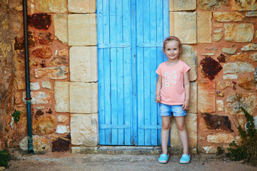 preschooler girl having fun near brick wall in Roussillon, Provence, Southern France