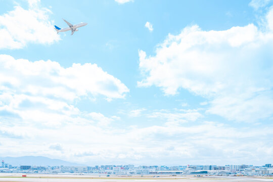 福岡空港の滑走路を離陸して青空に飛んでいく旅客機