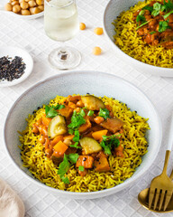 Yellow rice with fresh carrots ,cucumber and chickpeas on white background.
