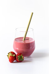 Glass strawberry smoothie with straw and fresh strawberry on white background.