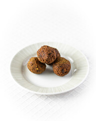 Falafel balls on white plate and white background.