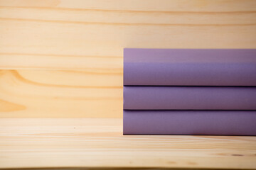 lilac books on natural wooden bookshelf, space for text